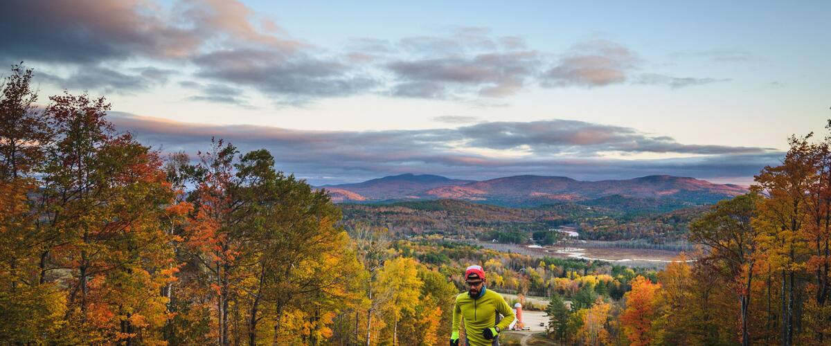Man trail running in mountains during foliage season