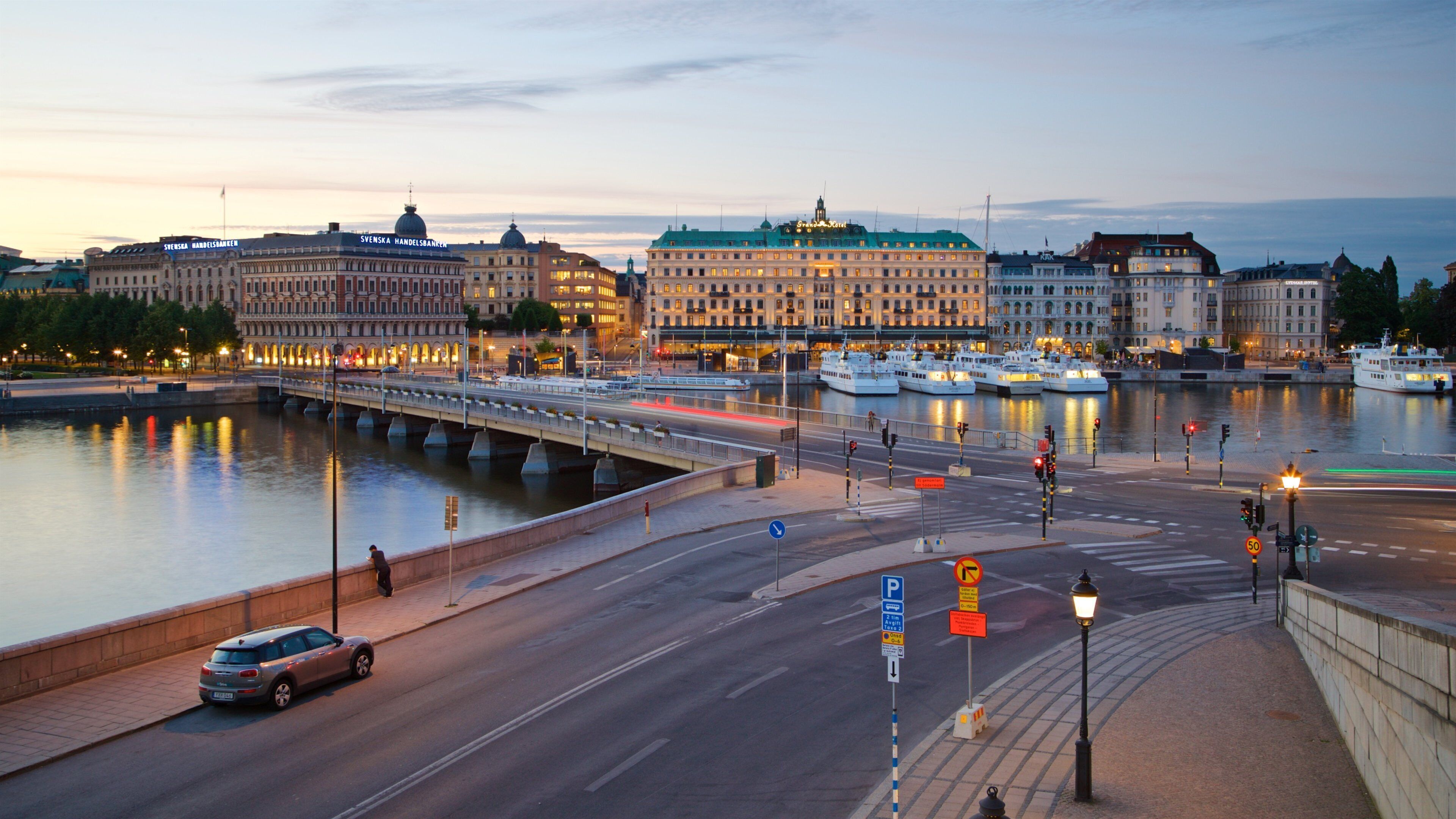 A waterfront cityscape with historic buildings, a bridge, and boats.