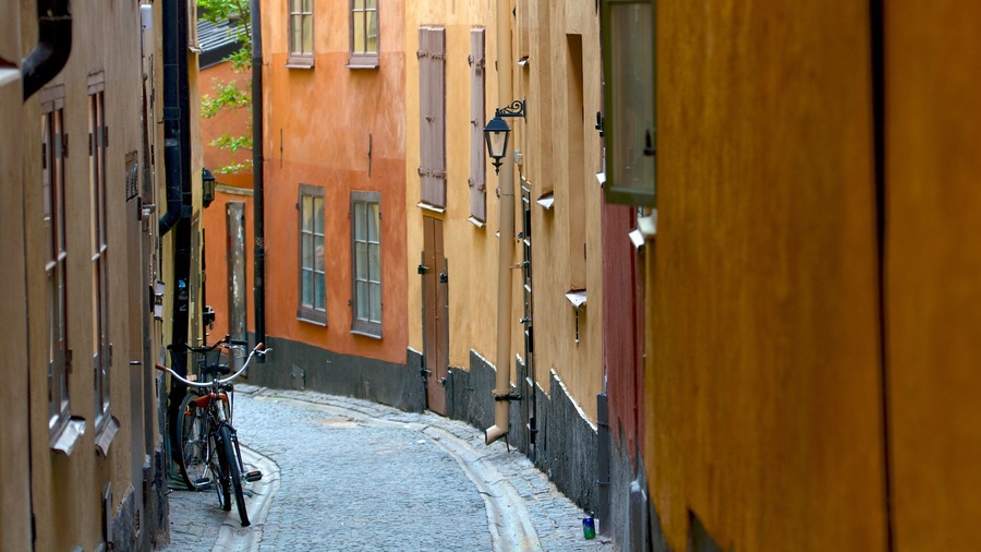 Eine schmale Kopfsteinpflasterstraße, gesäumt von bunten Häusern, mit einem Fahrrad links.