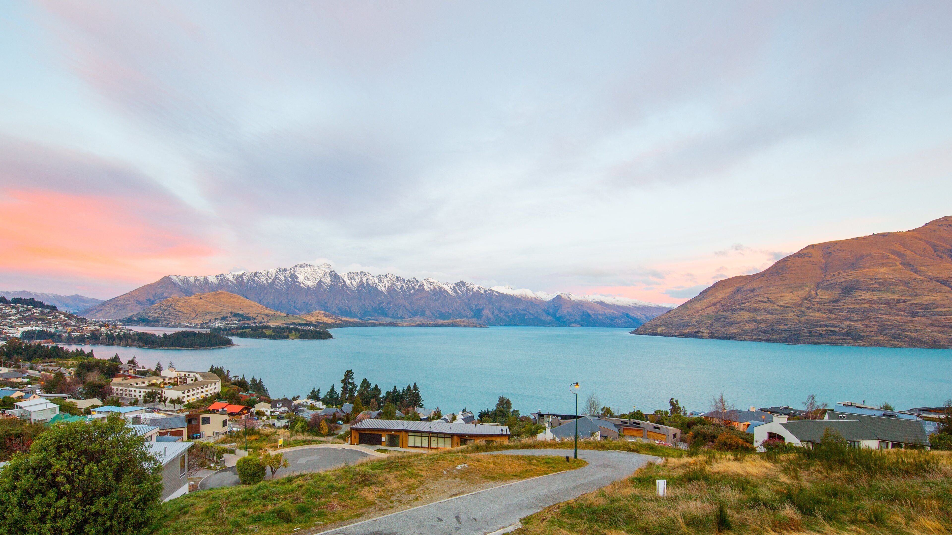 A lake surrounded by mountains and houses.