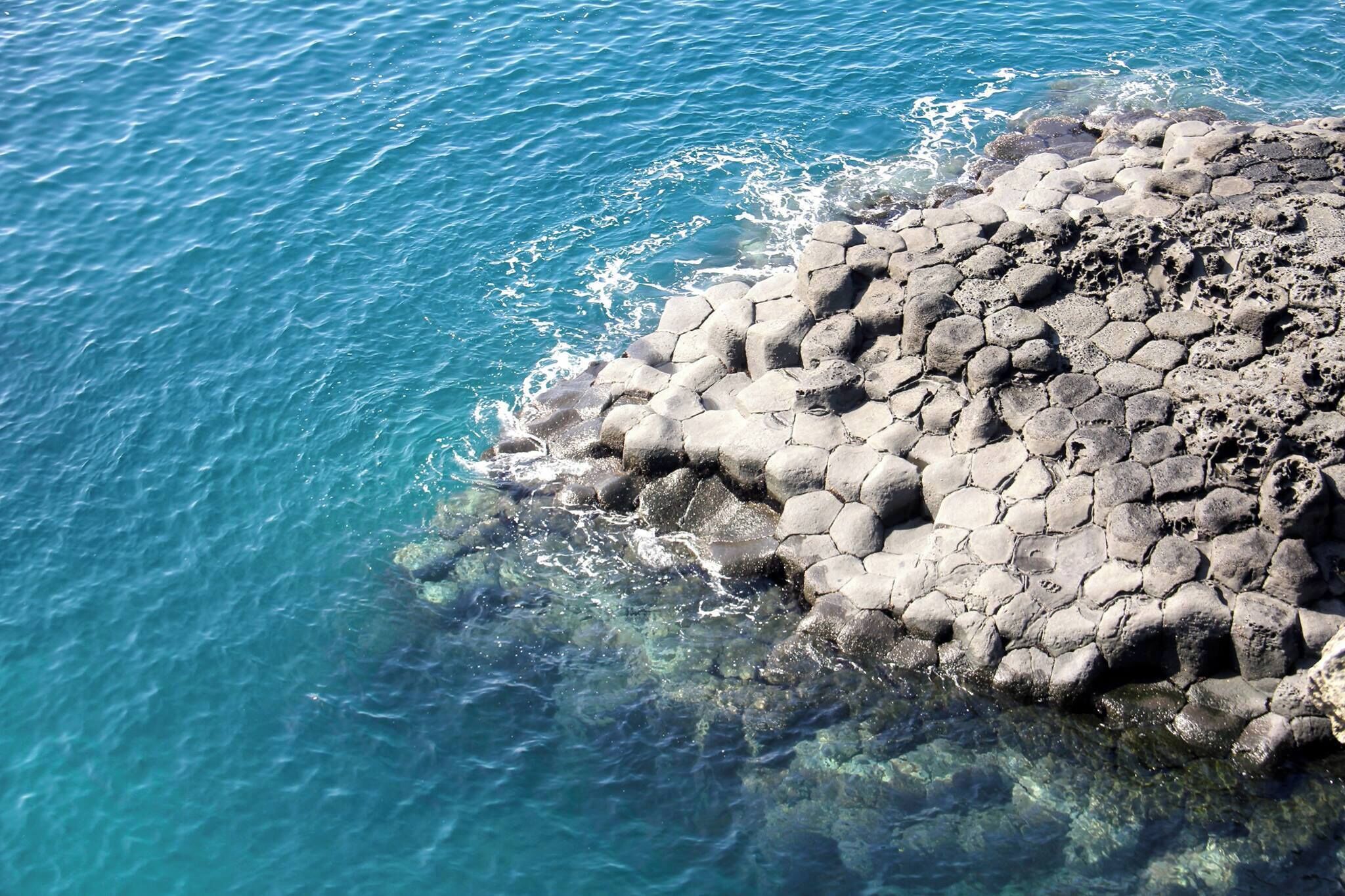 A rocky coastline with clear blue water.