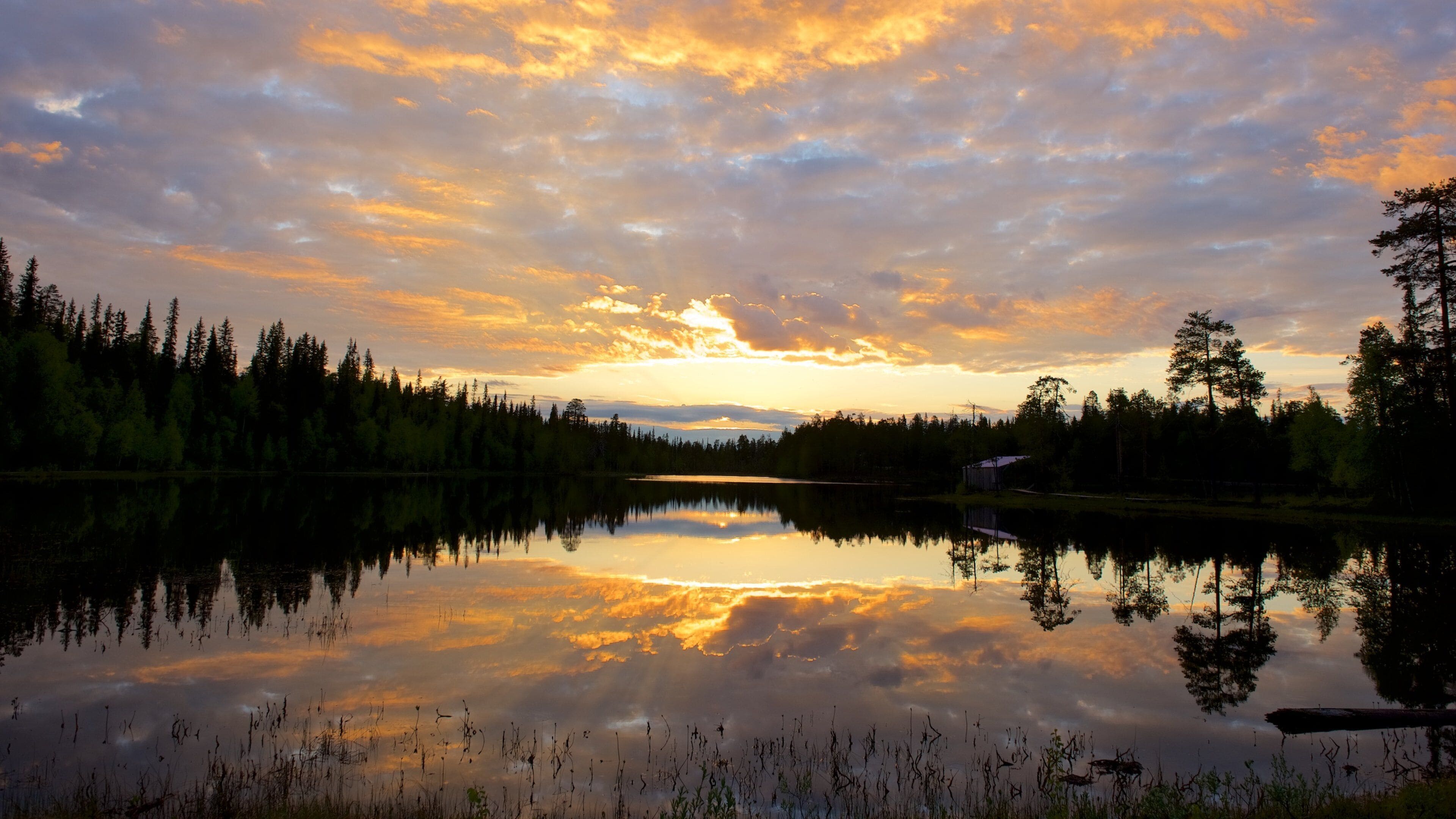 Luosto som inkluderer rolig landskap, elv eller bekk og solnedgang