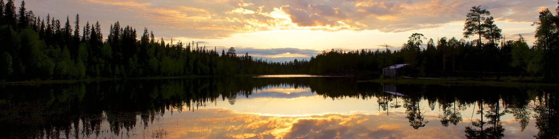 Luosto which includes a lake or waterhole and a sunset