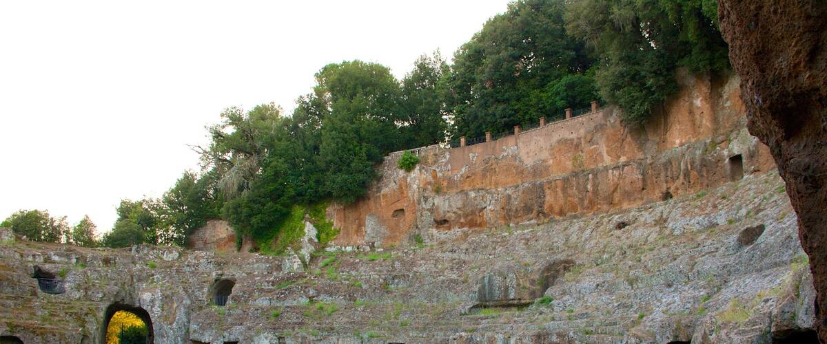 An ancient stone amphitheater with a central stage and multiple seating tiers.