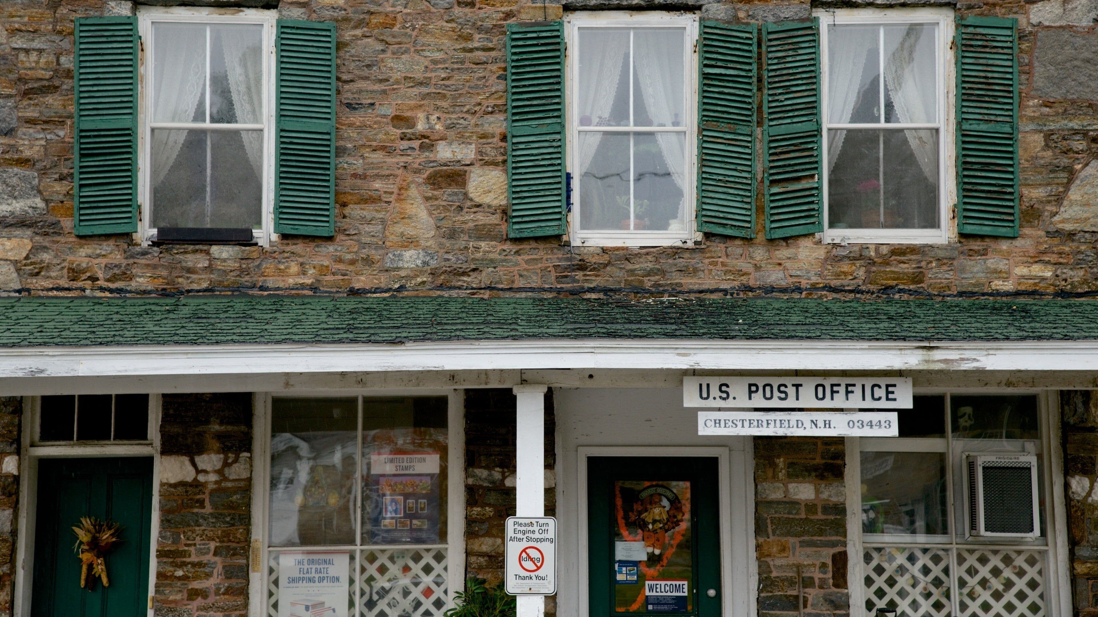 A U.S. Post Office in Chesterfield, N.H. with stone walls and green shutters.
