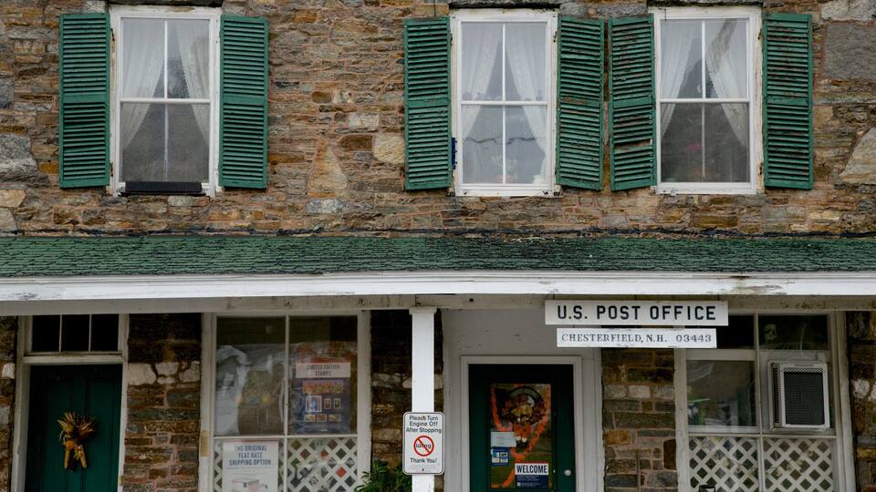 A U.S. Post Office in Chesterfield, N.H. with stone walls and green shutters.