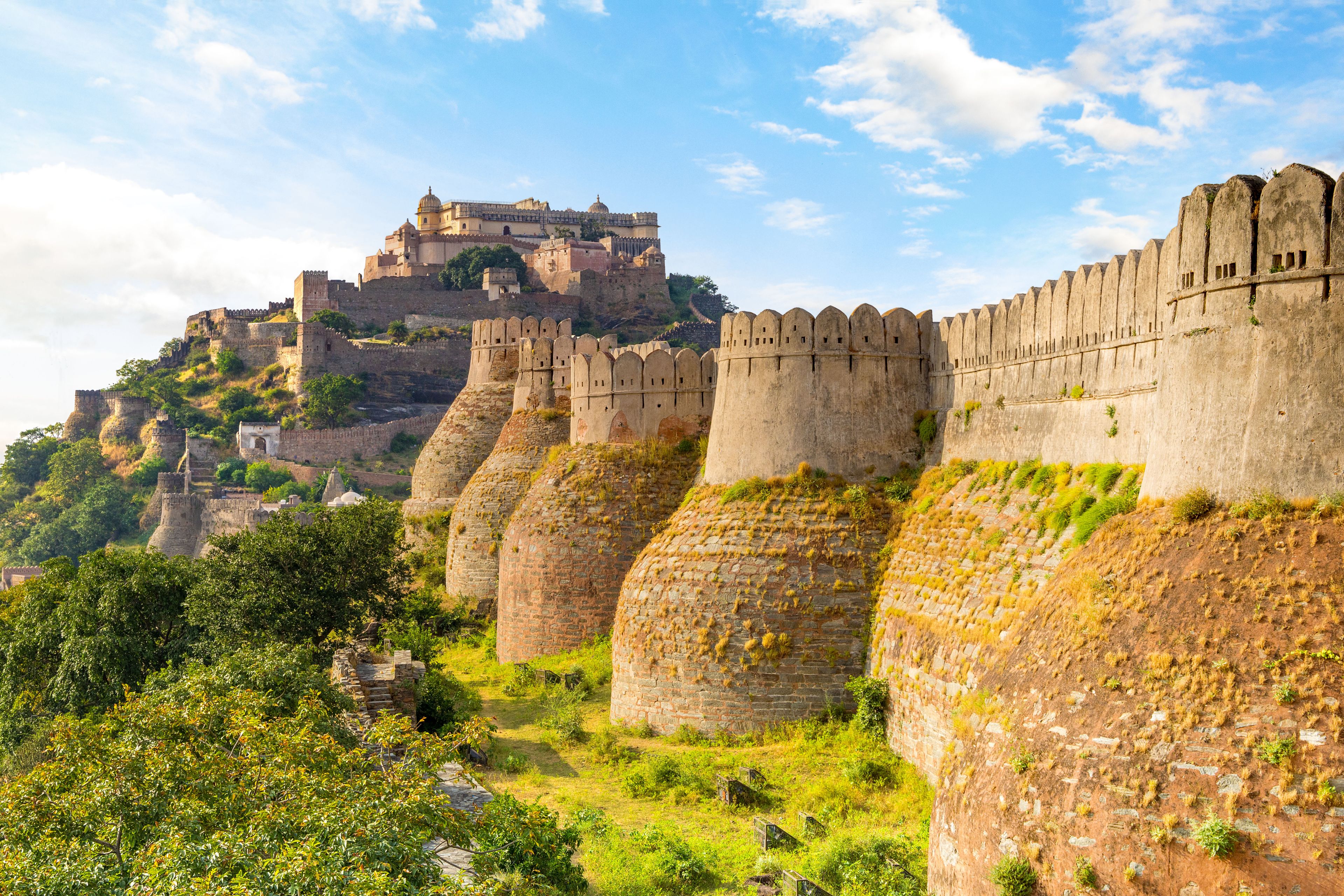 Une fortification historique dotée de multiples remparts et surmontée d’un château situé sur une colline.