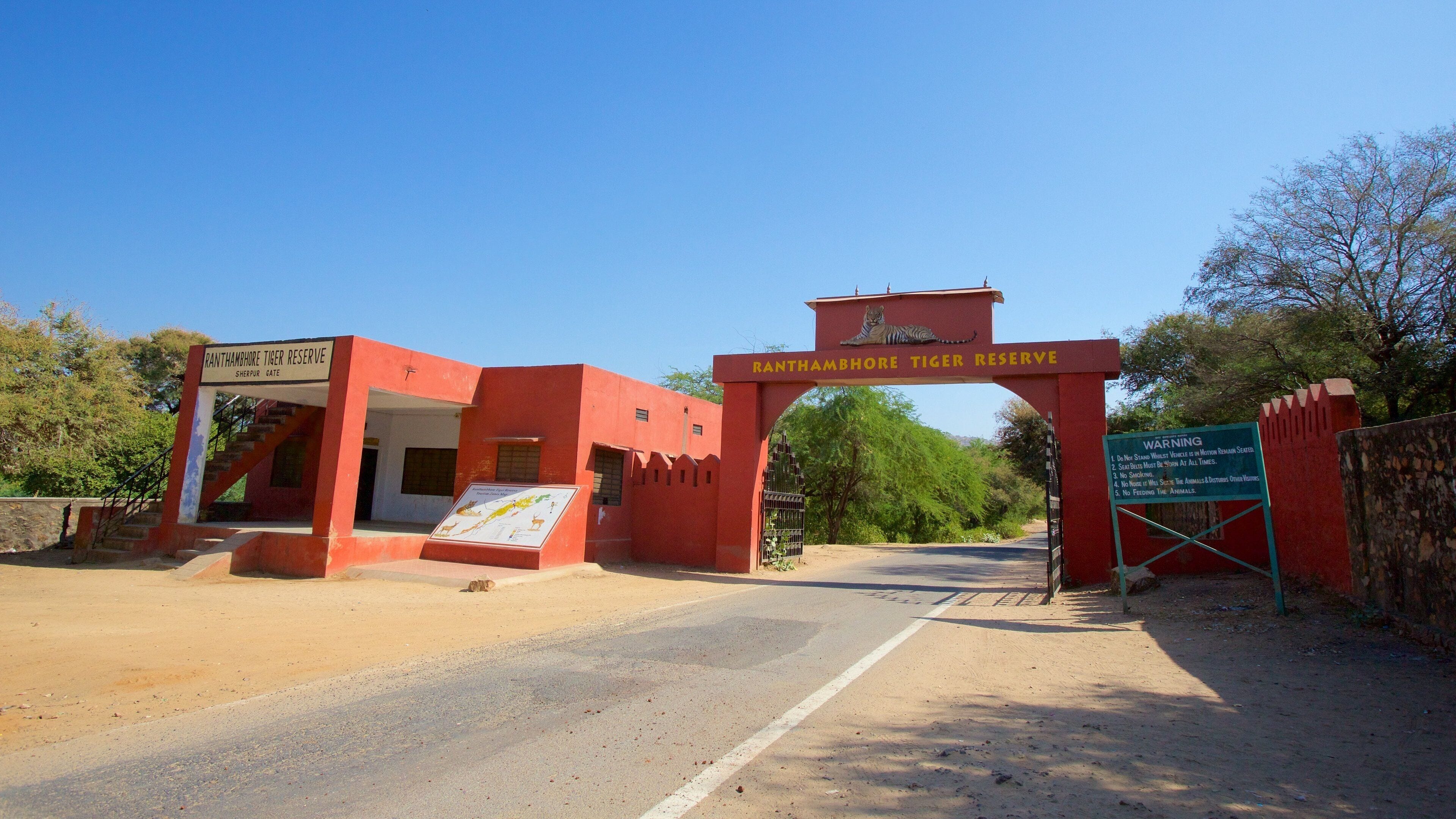 The entrance to the Ranthambhore Tiger Reserve with a signboard and a gate.