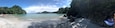 A beach with clear turquoise water, white sand, and rocky cliffs.