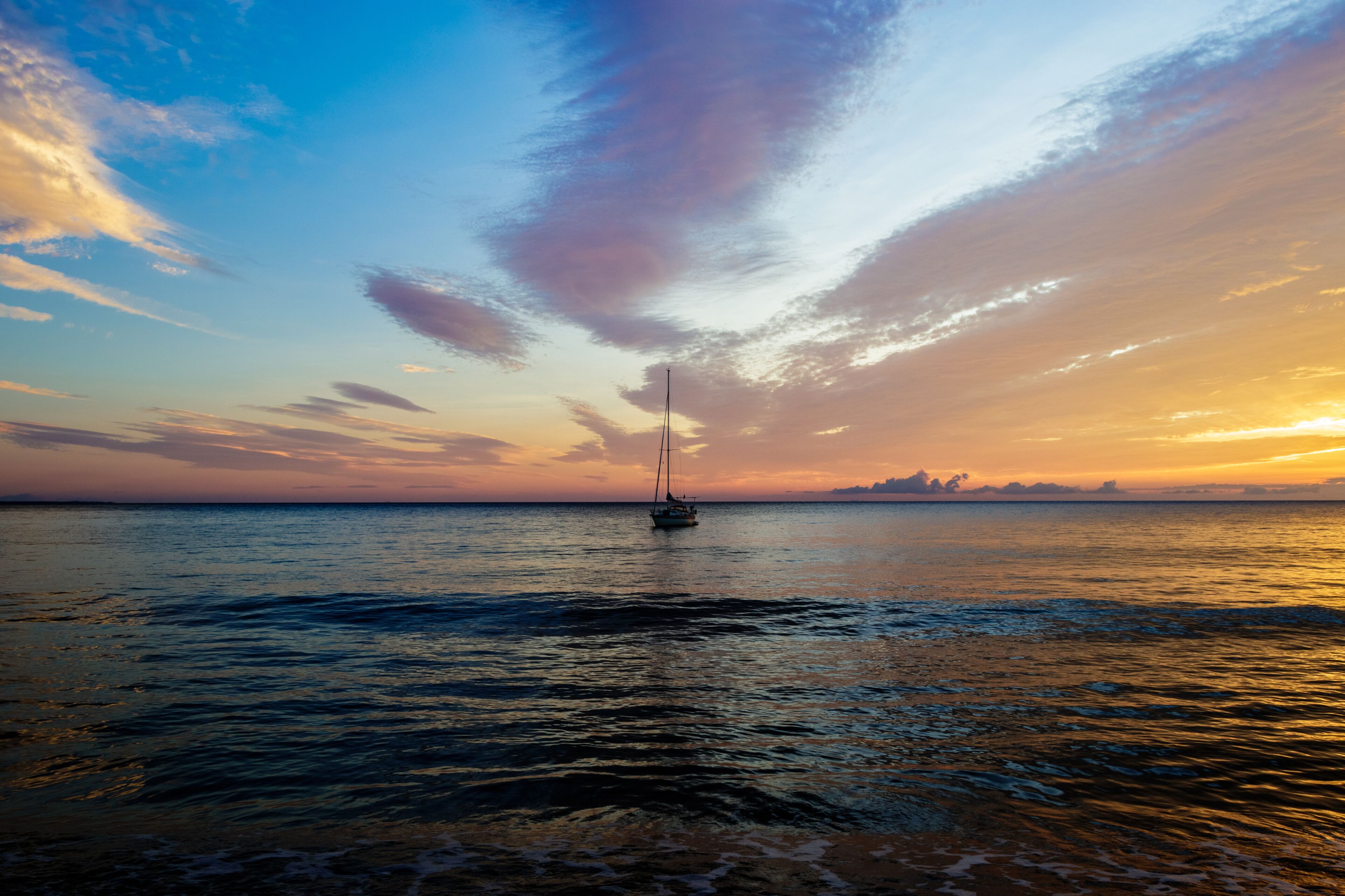 Sailing boath during sunrise on an early morning at the Solanzara beach on the island of corsica.