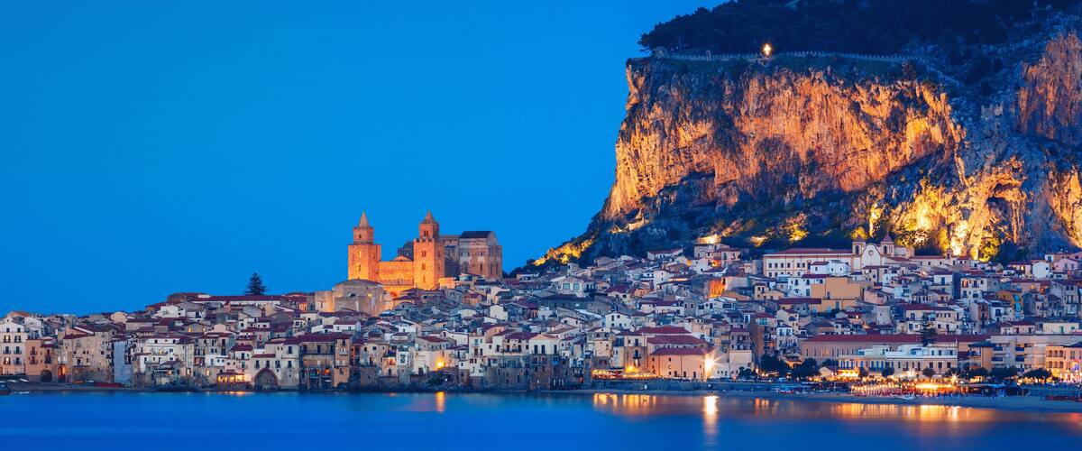 A coastal town with historic buildings and a prominent cliff.