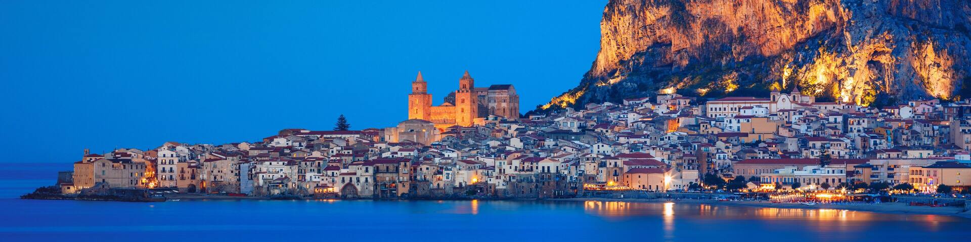 A coastal town with historic buildings and a prominent cliff.