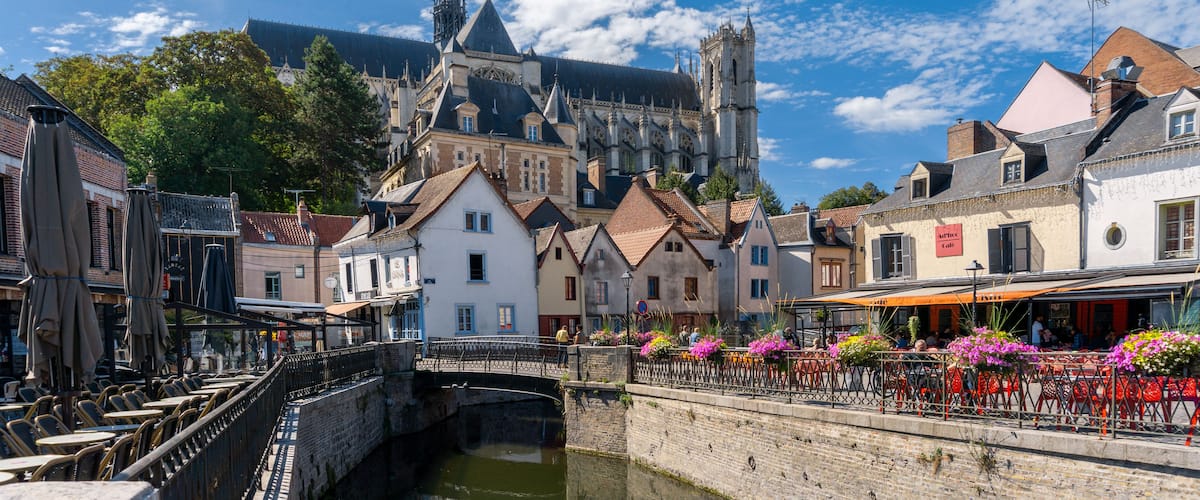 Un pueblo histórico con una catedral destacada, un puente y un canal.