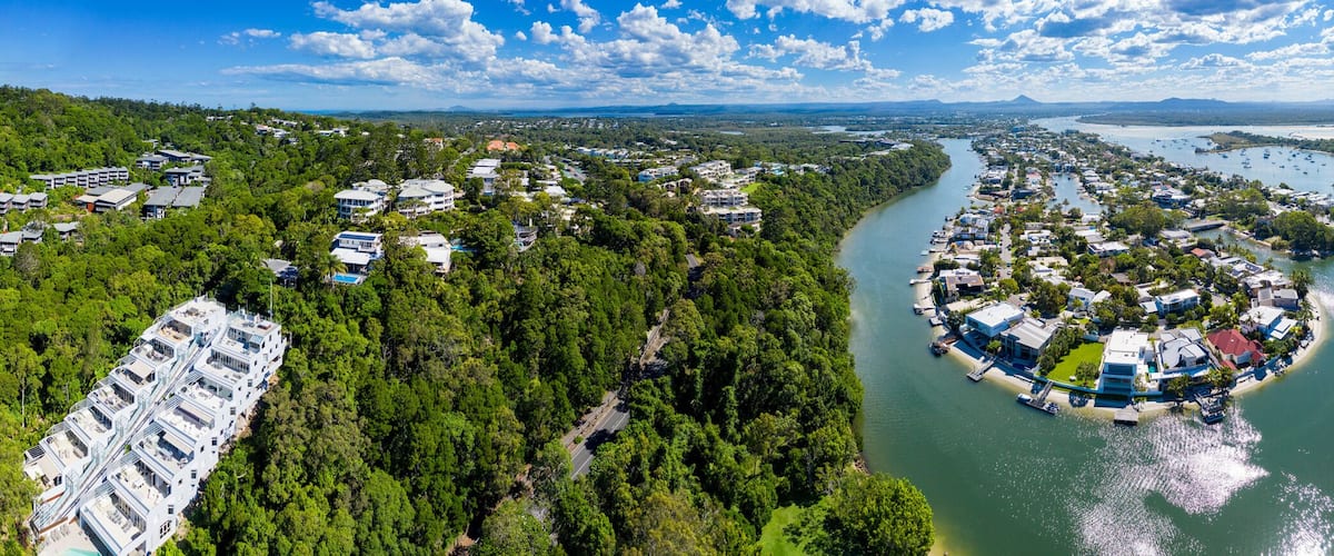 Un pueblo costero con un río, un puente y una playa.