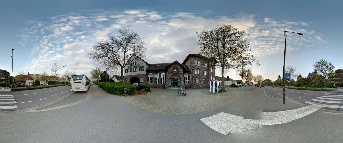 A roundabout with a large brick building, a bus, and a bicycle.