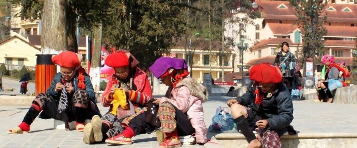 Red Dao women embroider their beautiful handmade textiles in the sun at the Sapa Town Square.