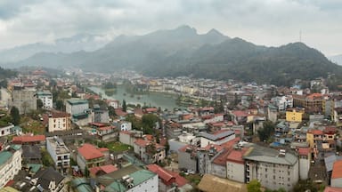 Aerial panorama of Sapa, Vietnam, showcasing its vibrant town, central lake, and surrounding misty mountains. A popular travel destination.