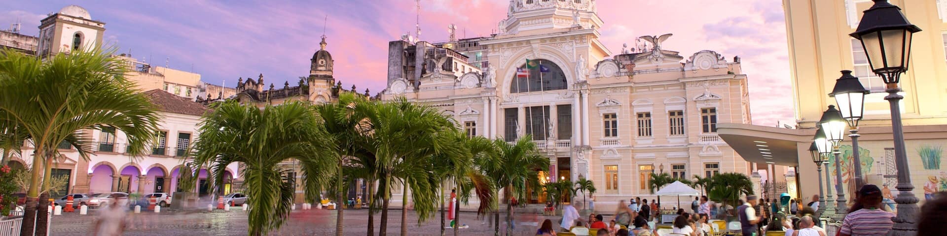 Salvador som inkluderar en solnedgÄng, en administrativ byggnad och al fresco-restauranger