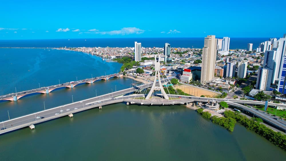 Une vue urbaine mettant en valeur un pont imposant, une rivière et un paysage côtier.