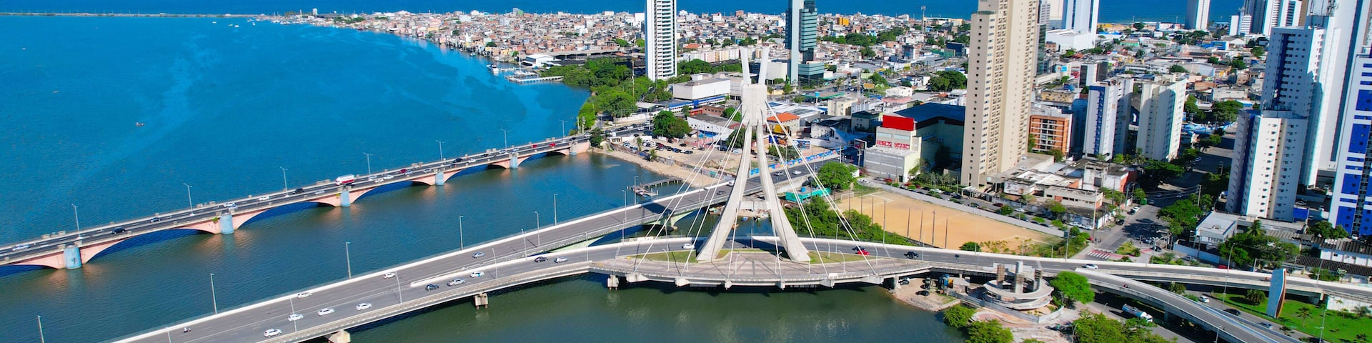 Eine Stadtansicht mit einer markanten Brücke, einem Fluss und Blick auf die Küste.