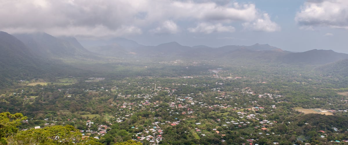 A mountainous landscape with scattered houses and a valley.