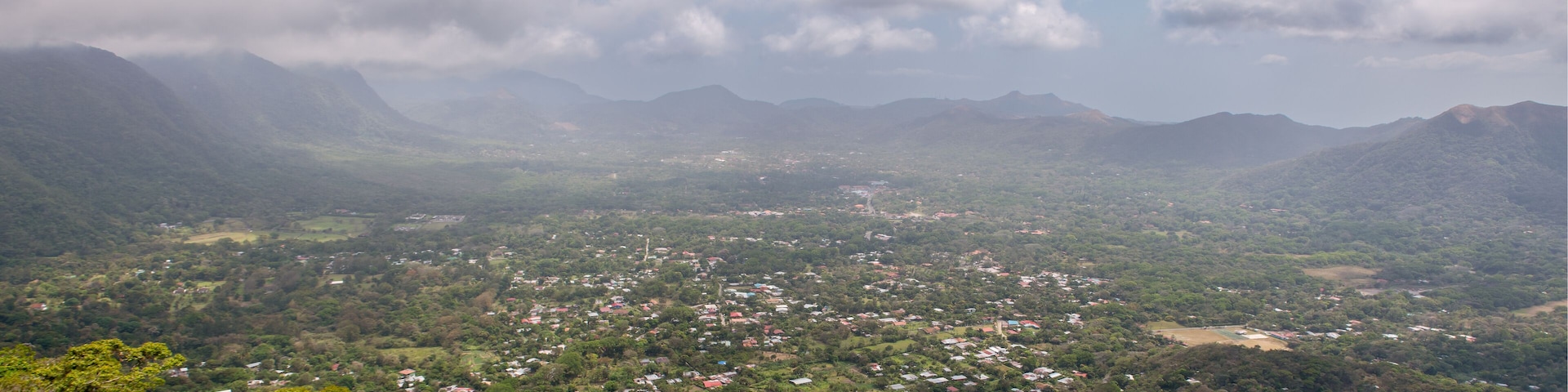 A mountainous landscape with scattered houses and a valley.