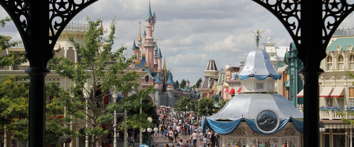A crowded street with a castle-like building in the background.