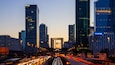 A cityscape with tall buildings, including RTE and Novotel, and a busy highway with light trails.