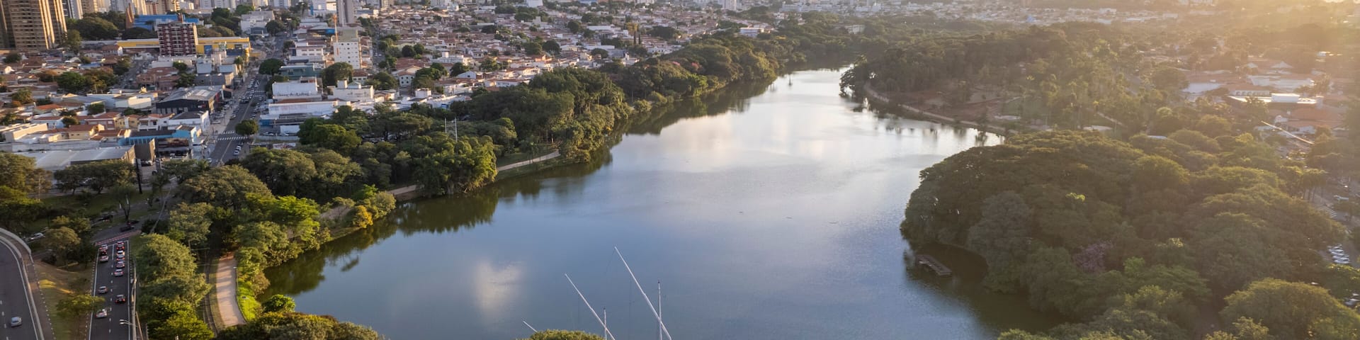 A river winding through a city with dense greenery on both sides.