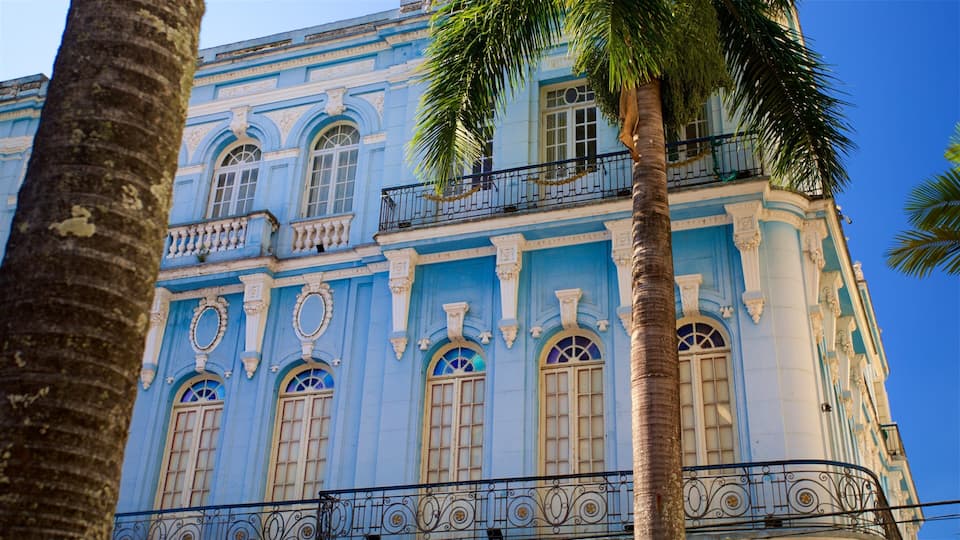 A blue building with ornate windows and a balcony.