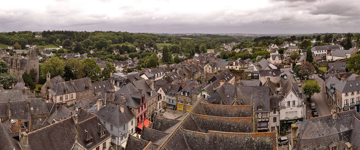 A historic town with medieval architecture, cobblestone streets, and a river in the background.