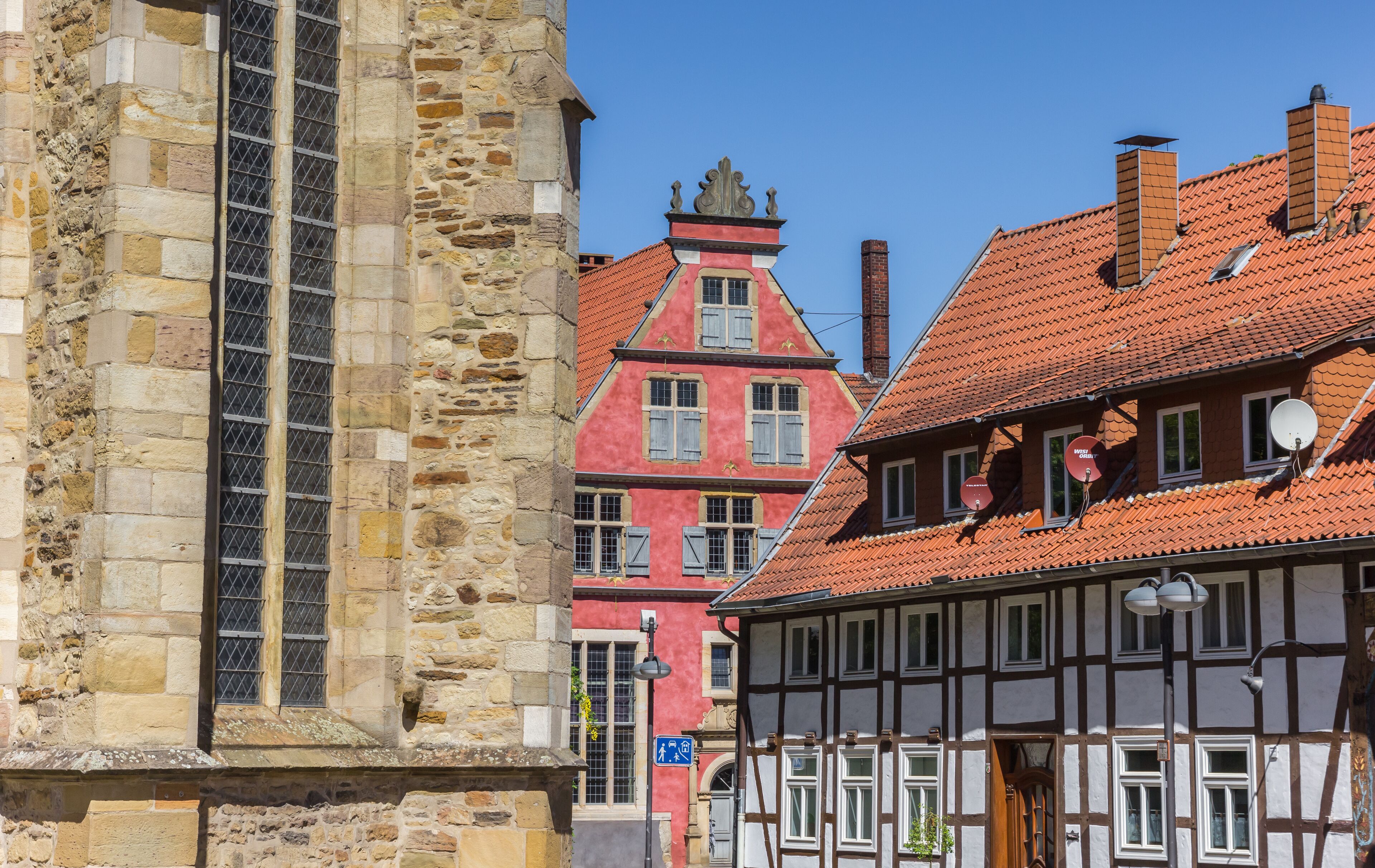 A historic town with stone buildings, a church, and traditional half-timbered houses.