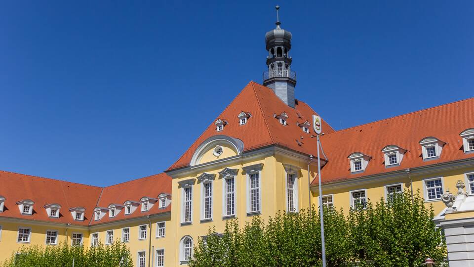 A historic building with a red-tiled roof and a prominent tower.