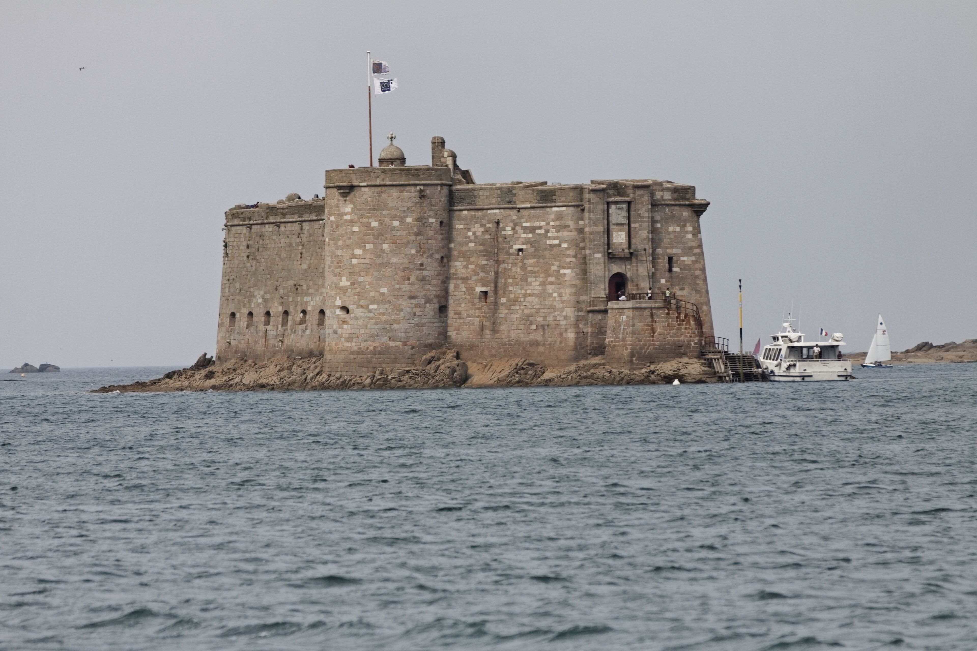 A historic stone castle on a small island surrounded by water.