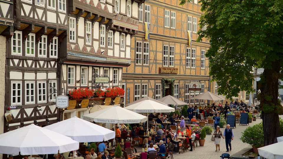 A bustling outdoor café with traditional half-timbered buildings in the background.