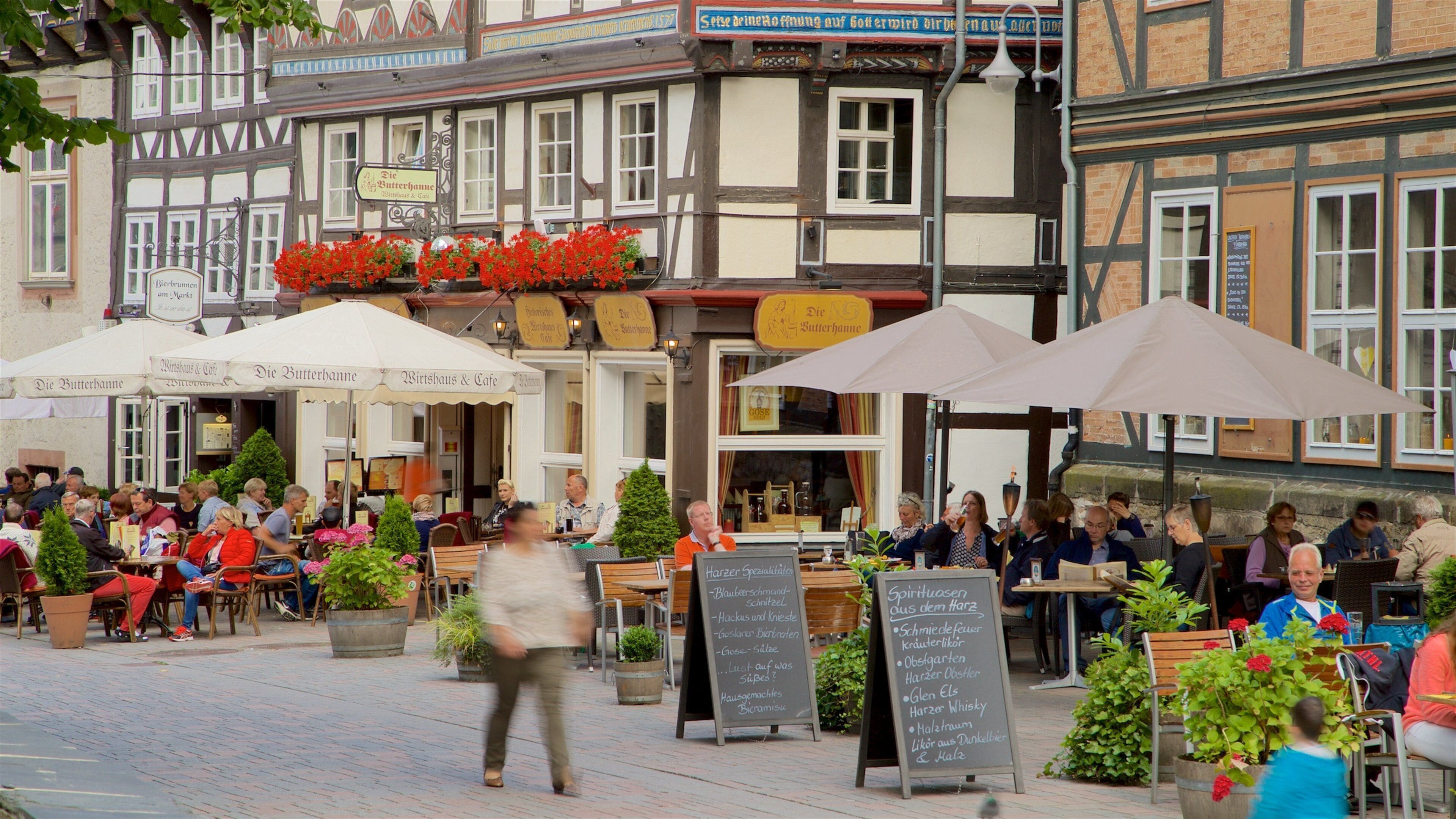 Goslar Altstadt mostrando sinalização e jantar ao ar livre assim como um pequeno grupo de pessoas