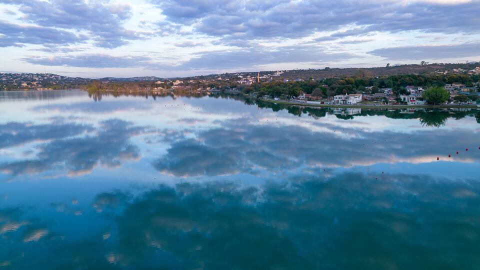 A calm lake with a town in the background.