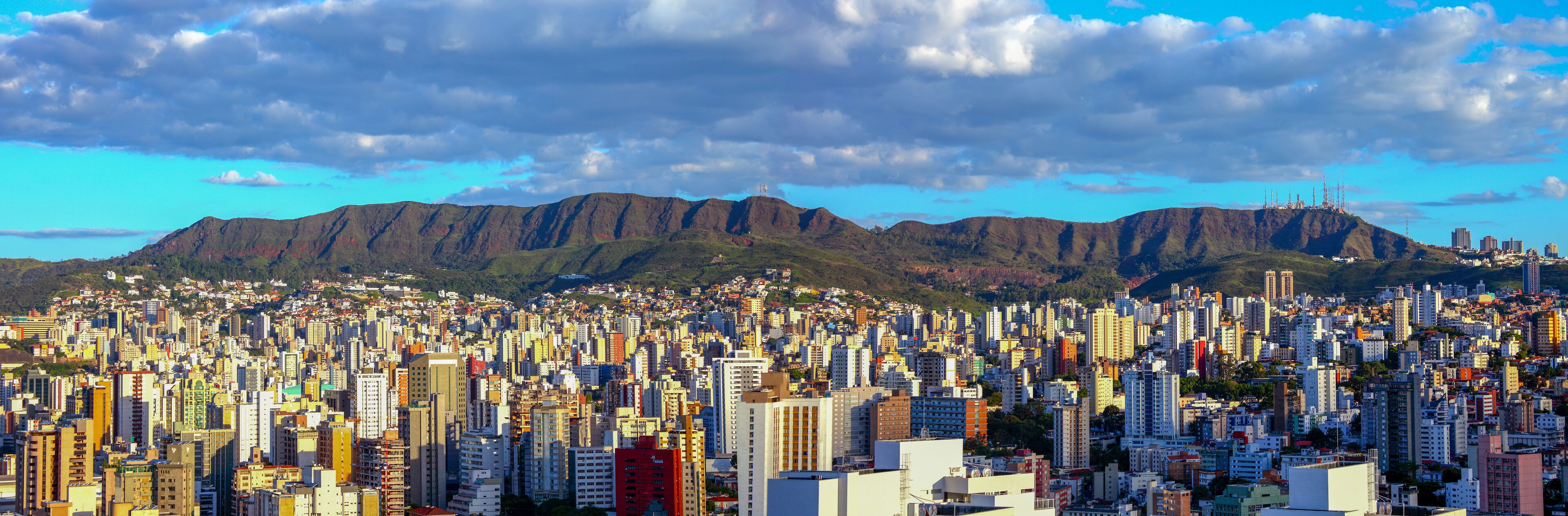 A densely populated cityscape with a mountain range in the background.