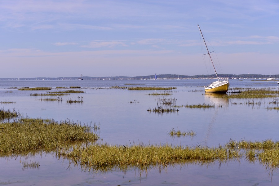 Sailboat at low tide at Arès, ostreicole commune located on shore of Arcachon Bay, in the Gironde department in southwestern France.