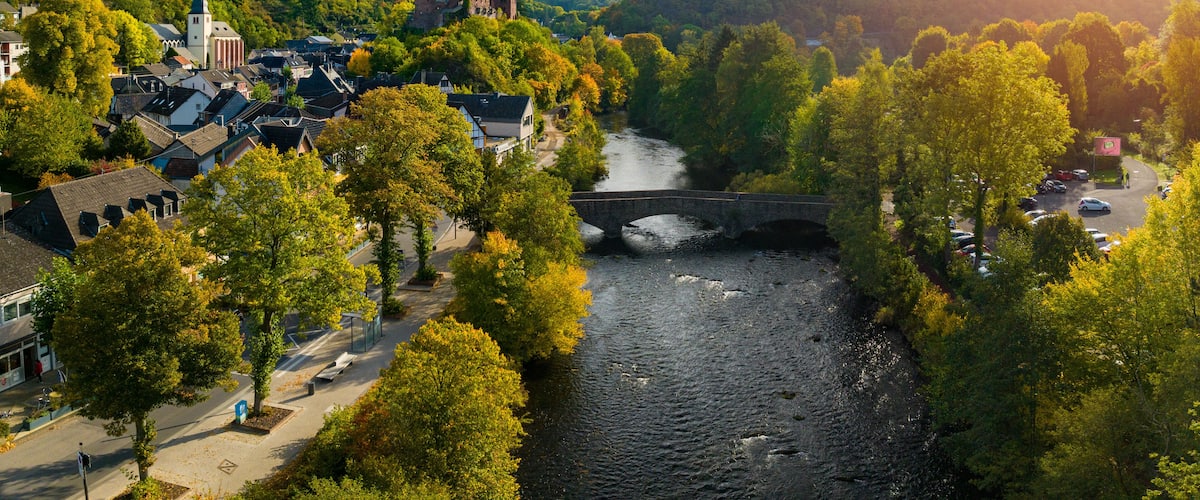 A town with a river, a bridge, and a hill with a church.