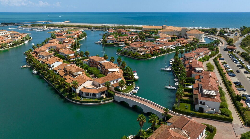 A coastal town with a marina, houses with red-tiled roofs, and a bridge connecting the areas.