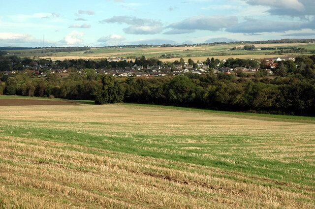 Barley stubble and woodland below Dunglass Farm Conon Bridge in background