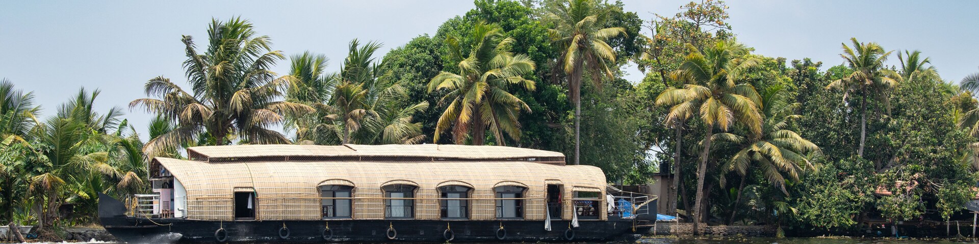 Una casa flotante en el agua rodeada de palmeras.