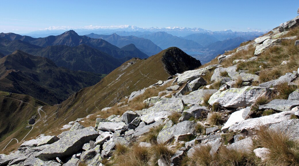 An der Südflanke geht es Aufwärts zum Monte Marmontana ( 2316 m.ü.M.). Der Berg liegt genau im Grenzbereich zwischen der Schweiz und Italien. In der Bildmitte liegt der Cima di Cugn (2180 m.ü.M.) mit dem gleichnamigen Rifugio. Links unten ist der Passo San Jorio (2010 m.ü.M.), Grenzpunkt zwischen Italien und der Schweiz. In der Ferne ist der Lago Maggiore zu sehen.