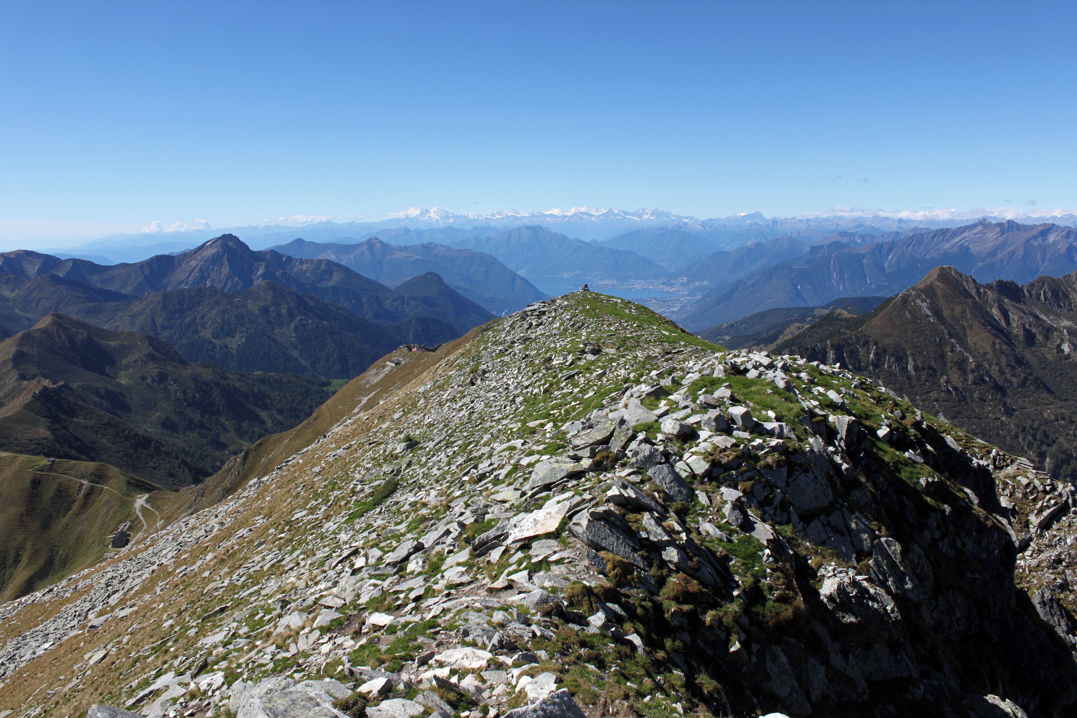 Auf dem Gipfel des Monte Marmontana ( 2316 m.ü.M.) über den genau die Grenze zwischen der Schweiz und Italien verläuft. Hier geht der Blick zum Passo San Jorio (2010 m.ü.M.) (links im Bild) und dann weiter zum Lago Maggiore bis zum mächtigen Monte Rosa.