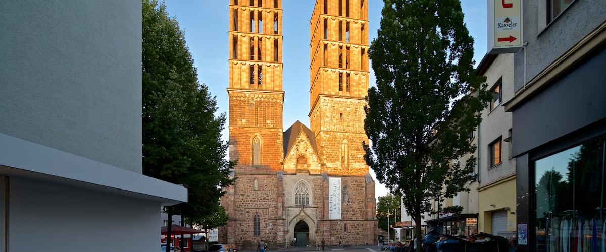 A historic church with two tall spires and a large banner.