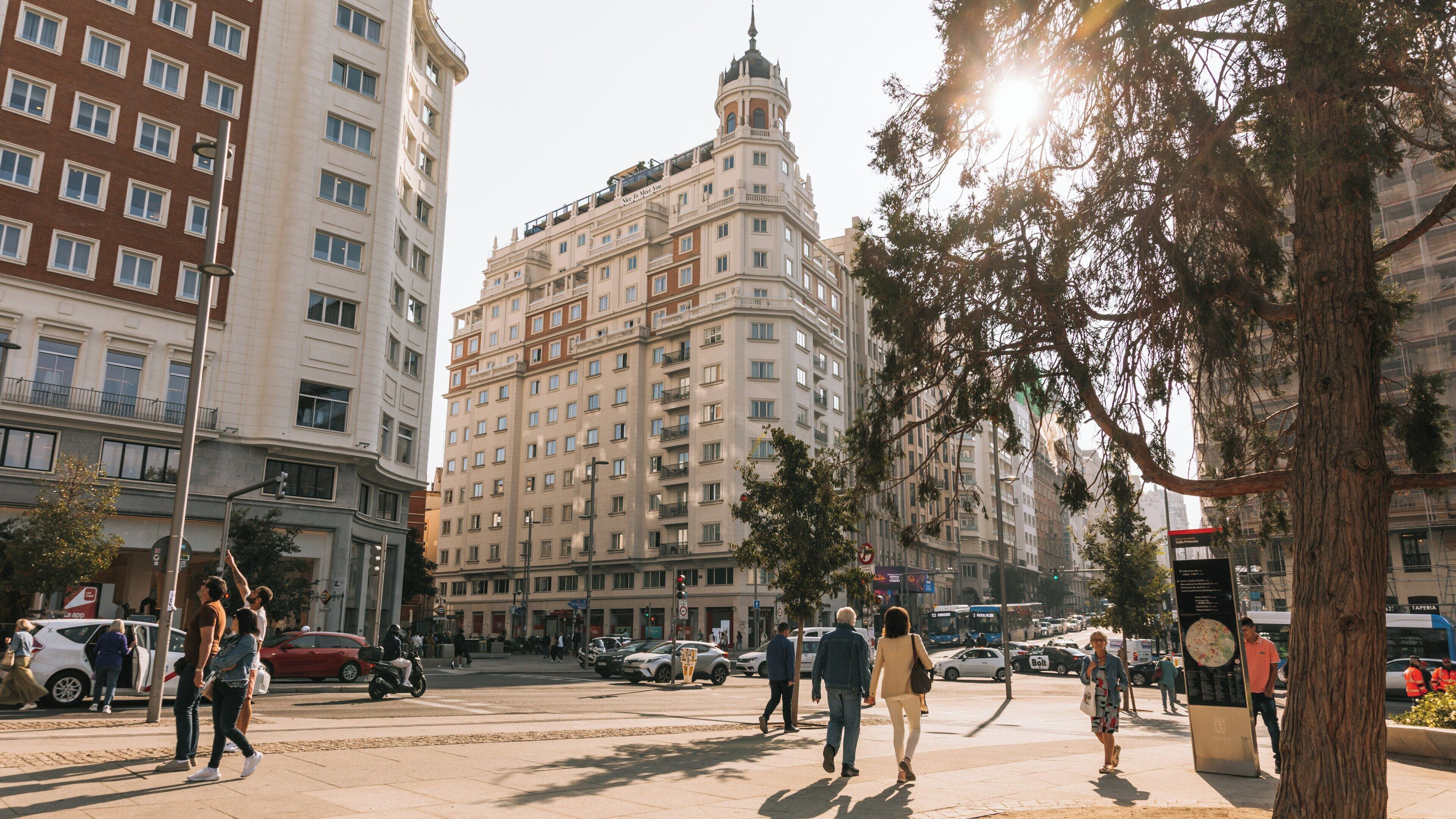 Exploring Plaza de Espana in Malasana, Madrid with bustling streets and historic architecture on a sunny day