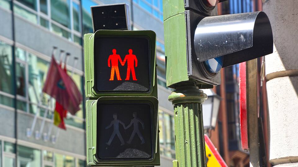 Red traffic light with a same-sex couple for Pride festival in Madrid's Chueca gay district
