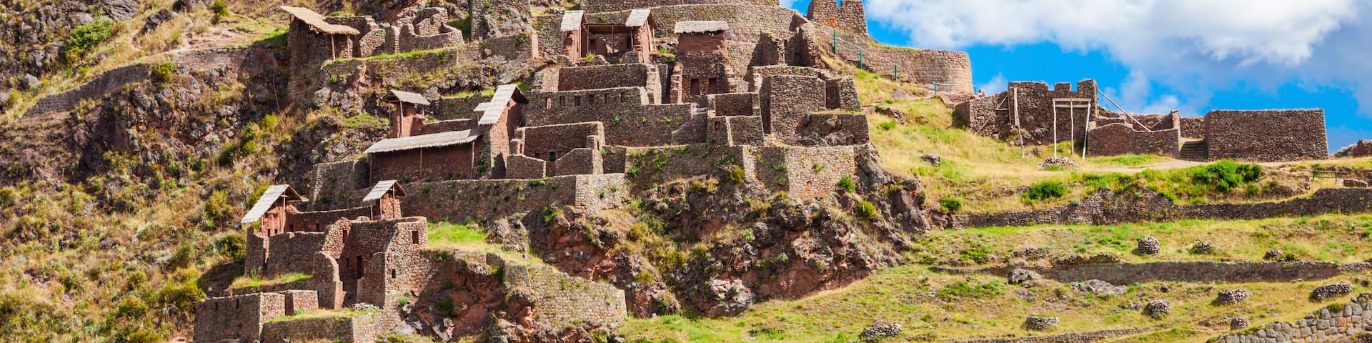 Ancient ruins on a hillside with stone structures and pathways.