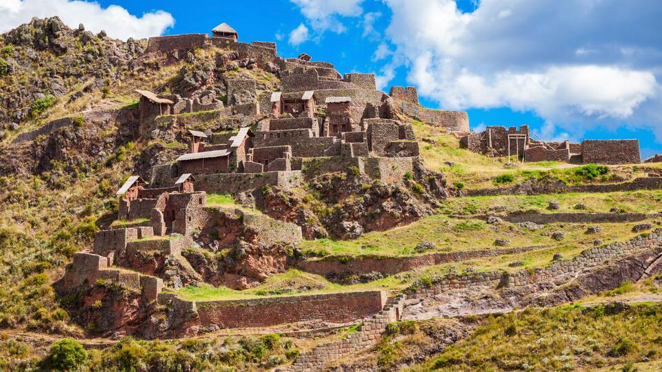 Ancient ruins on a hillside with stone structures and pathways.